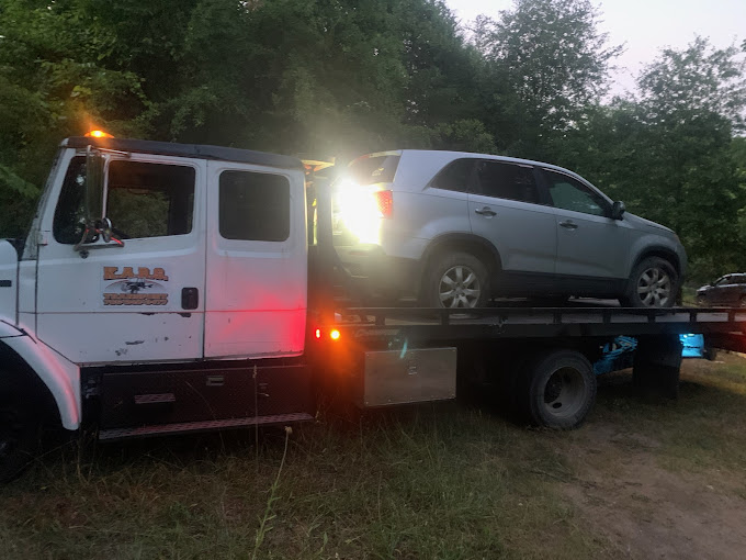 A tow truck with a car on the back of it