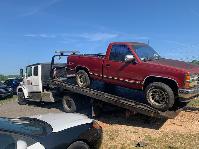 A red pick up truck on a flatbed trailer