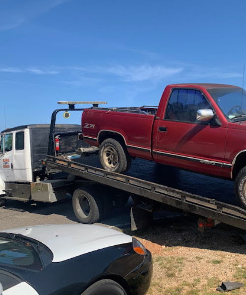 A red pick up truck on a flatbed trailer