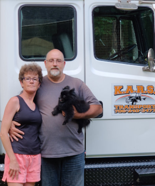 A man and a woman standing in front of a truck