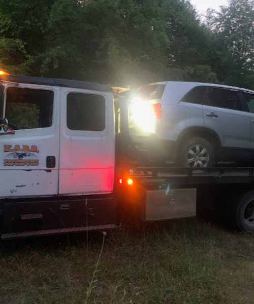 A tow truck towing a car on the back of it